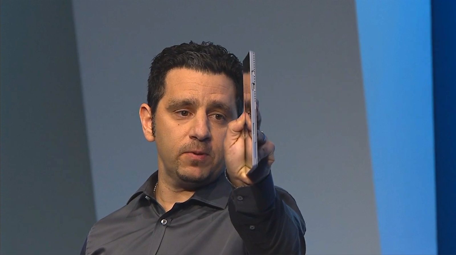 Panos Panay holds the device edge-on for the audience to see how thin it is.