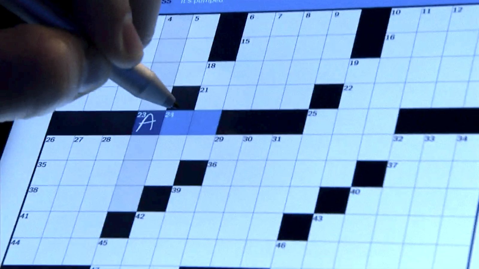 Panos Panay writes the letter ‘A’ into a box on a crossword.